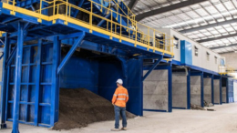 A Rowcon worker in a high vis shirt look at recycling machinery